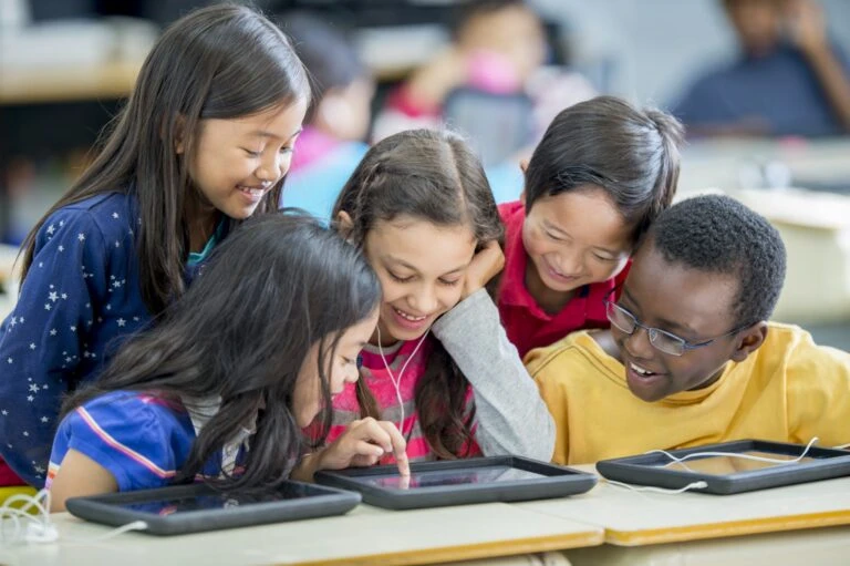 Children using tablets together in a classroom